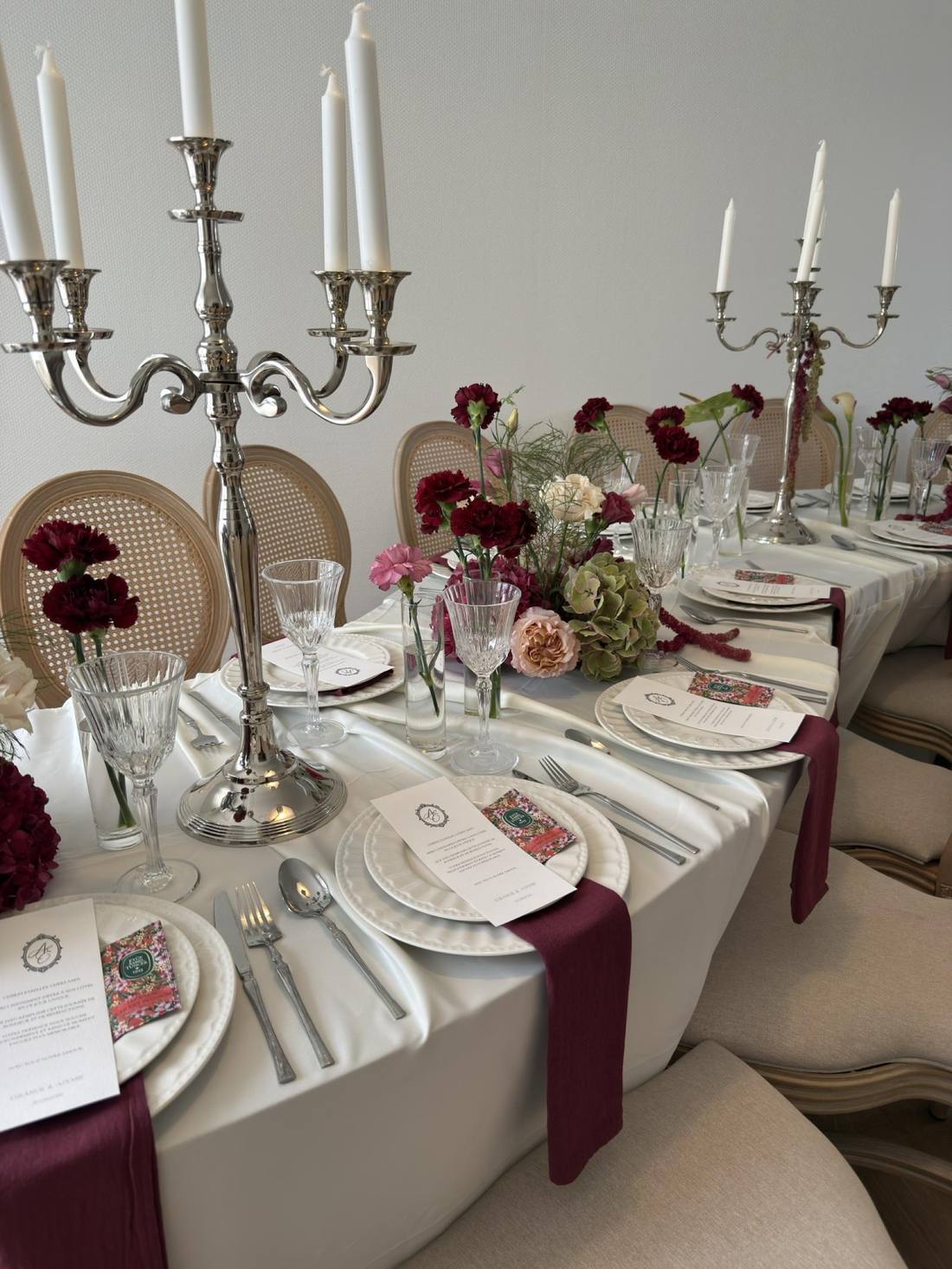 Table dressée, chandelier et œillets bordeaux